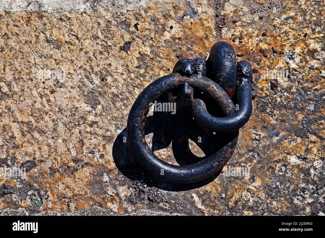 Old iron mooring ring on a stone dock Stock Photo
