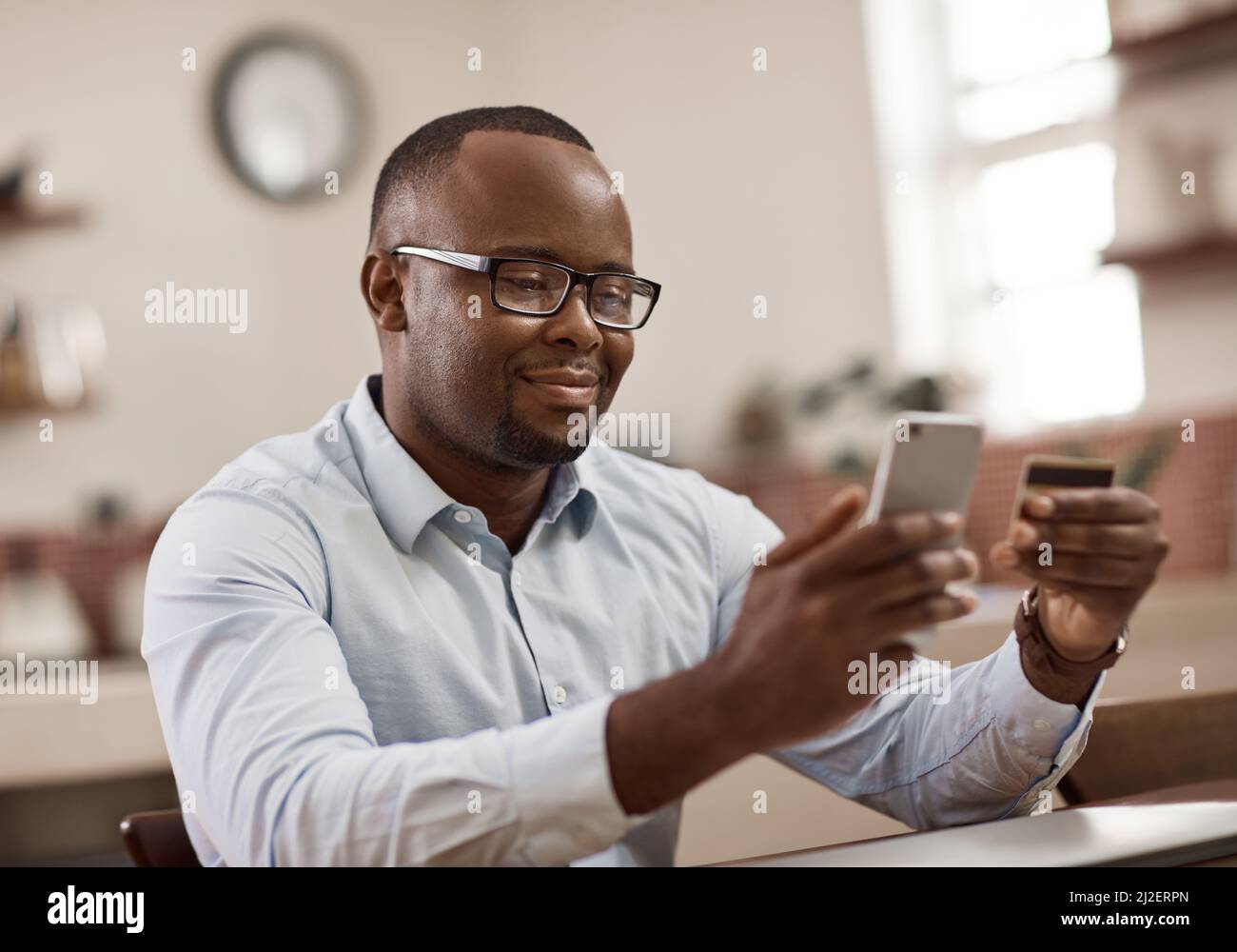 Theres no easier way to bank. Cropped shot of a handsome young businessman sending a text message while working at home. Stock Photo