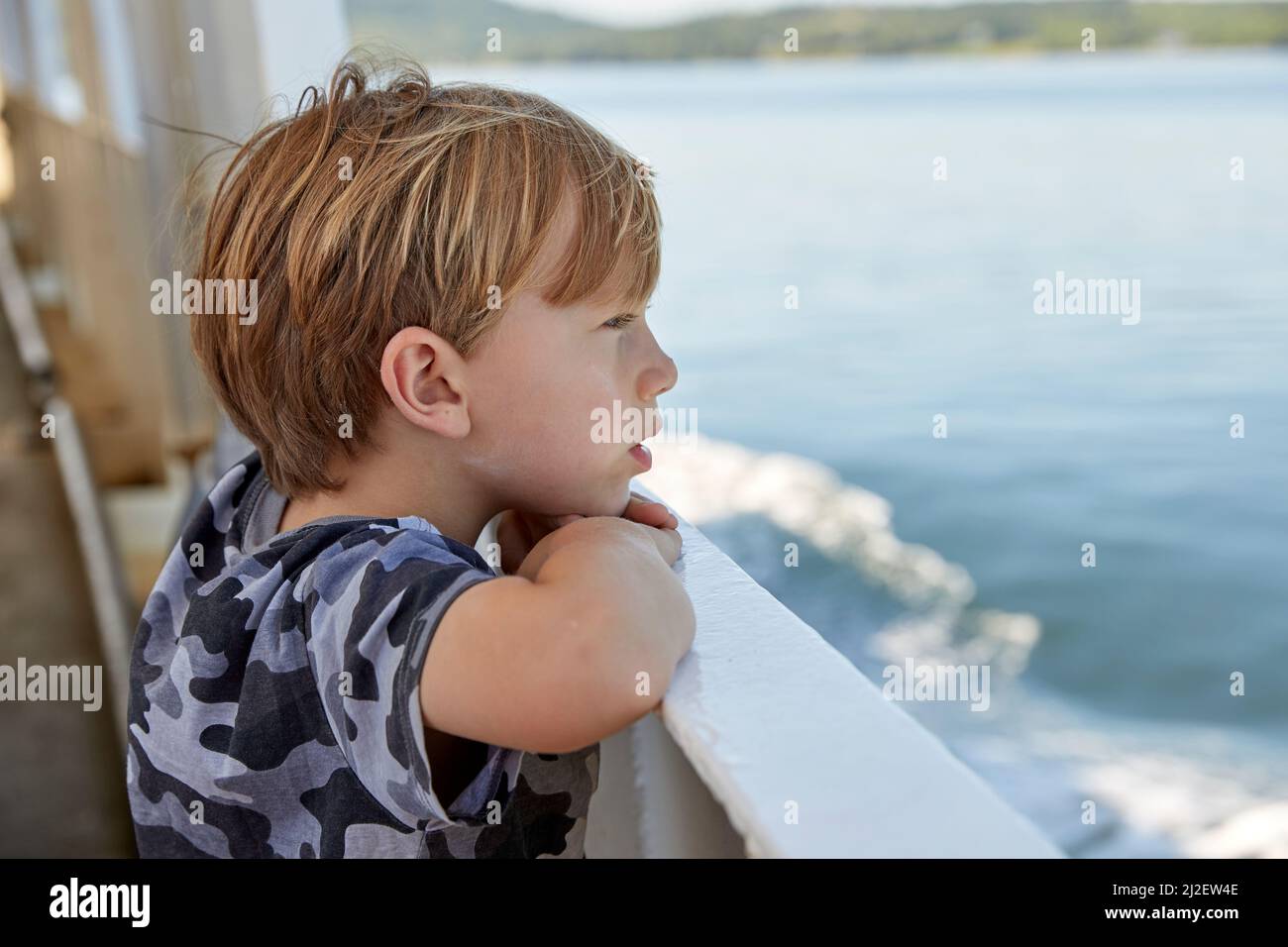 Boy looking out to ocean Stock Photo