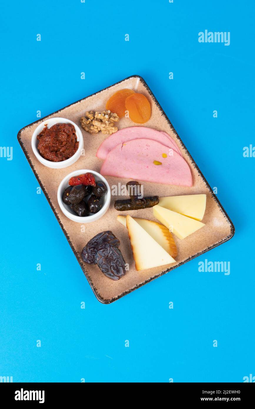 mage of walnuts, olives, tomato paste, cheese slices, wrap, ham, dried apricots, date and cheddar cheeses. Stock Photo