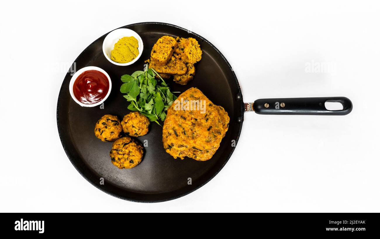 Gujarati Snacks Muthia In Different Shape On Nonstick Pan With Green Chutney And Ketchup Sauce Stock Photo