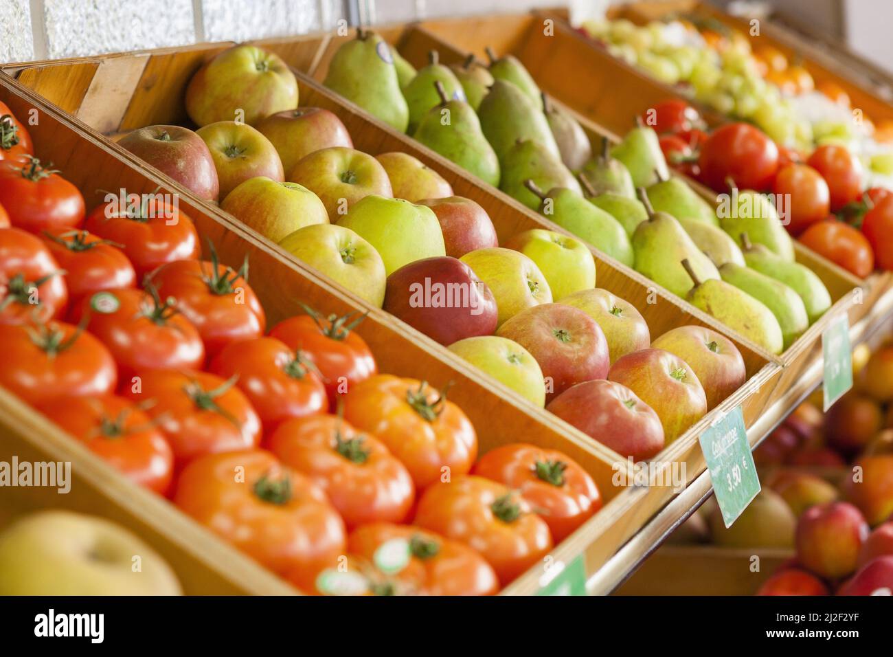 A selective focus shot of fruits and vegetables in wooden crates and ...