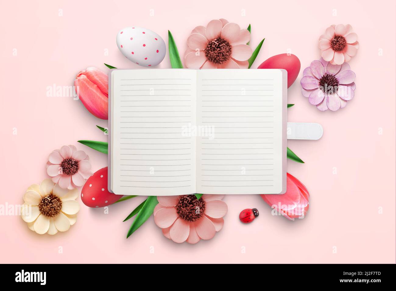 Notebook surrounded by Easter decorations. Blank paper for greeting text. Top view, flat lay Stock Photo