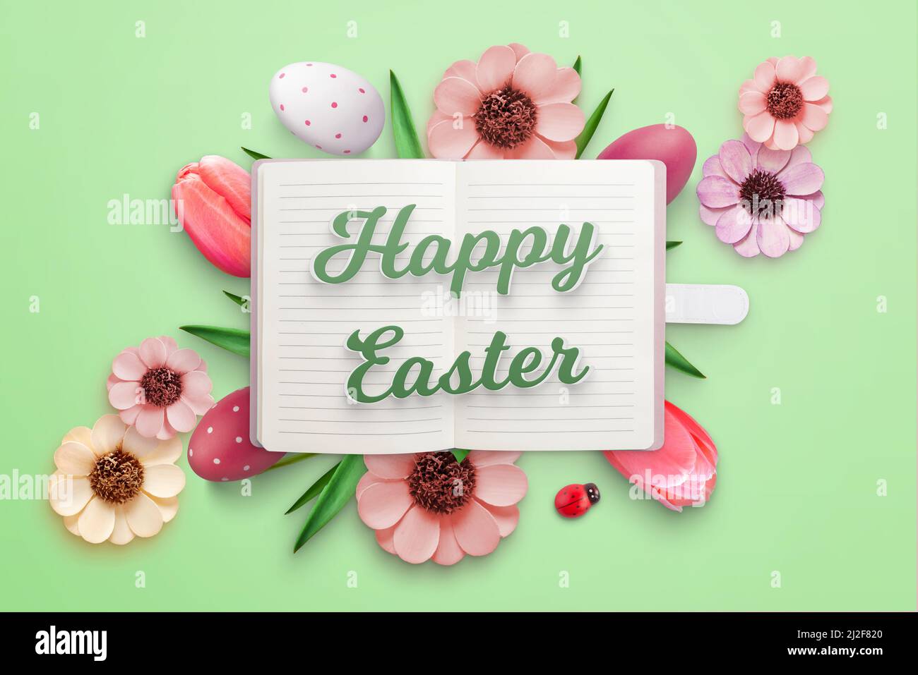 Happy Easter greeting card with notebook and Easter eggs and flowers Stock Photo