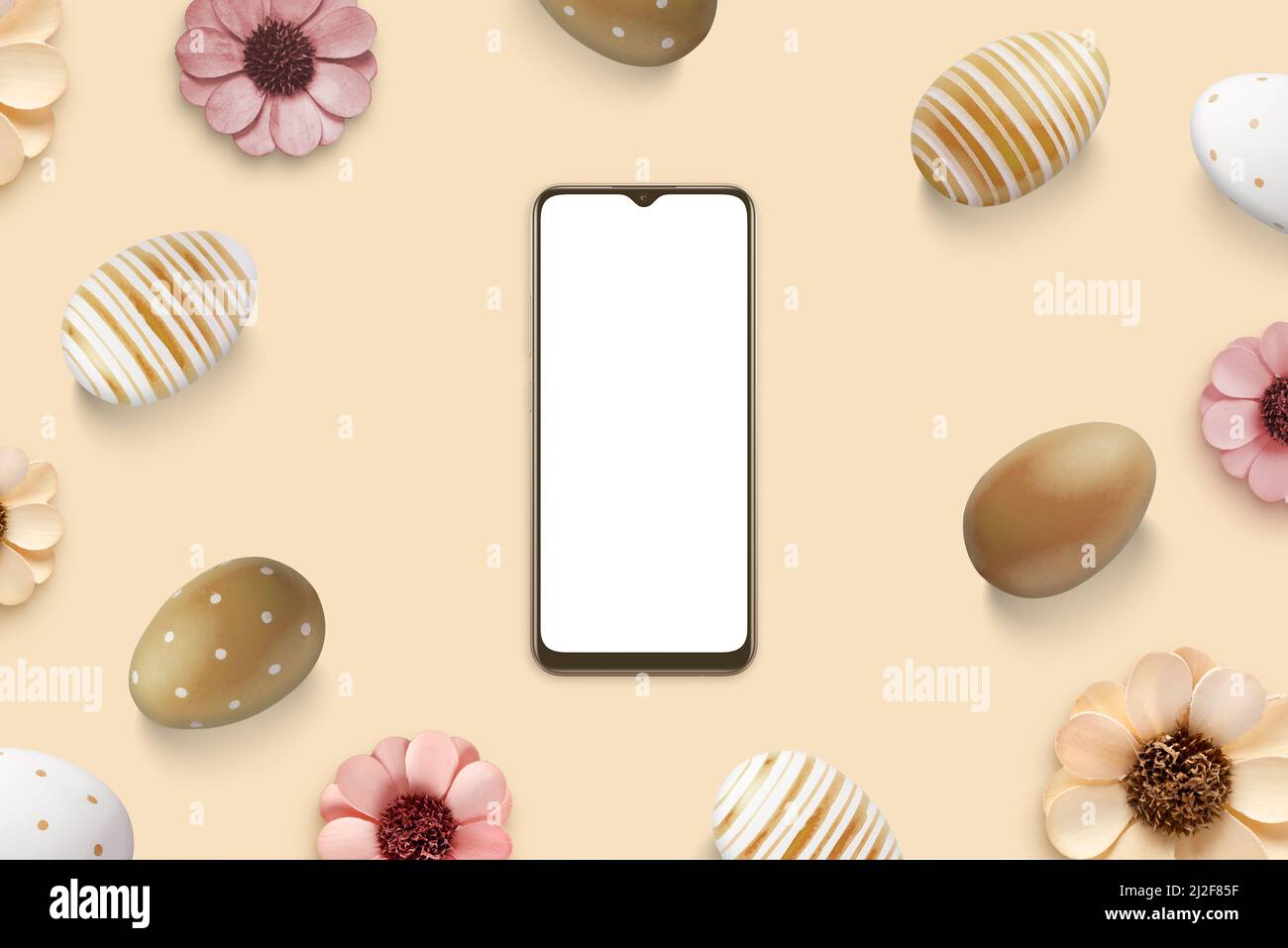 Phone mockup surrounded by Easter eggs and flowers. Top view, flat lay composition. Isolated screen for app design presentation Stock Photo