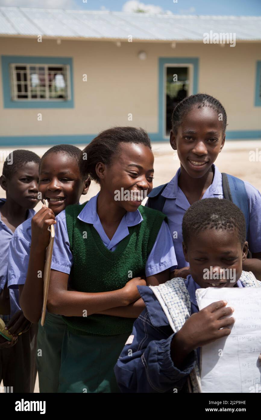 A group of primary school students stand together in the courtyard of