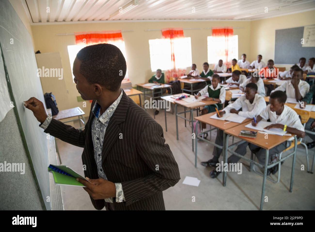 African secondary school teacher teaching from the front of the classroom in Oshana Region, Namibia, southern Africa. Stock Photo