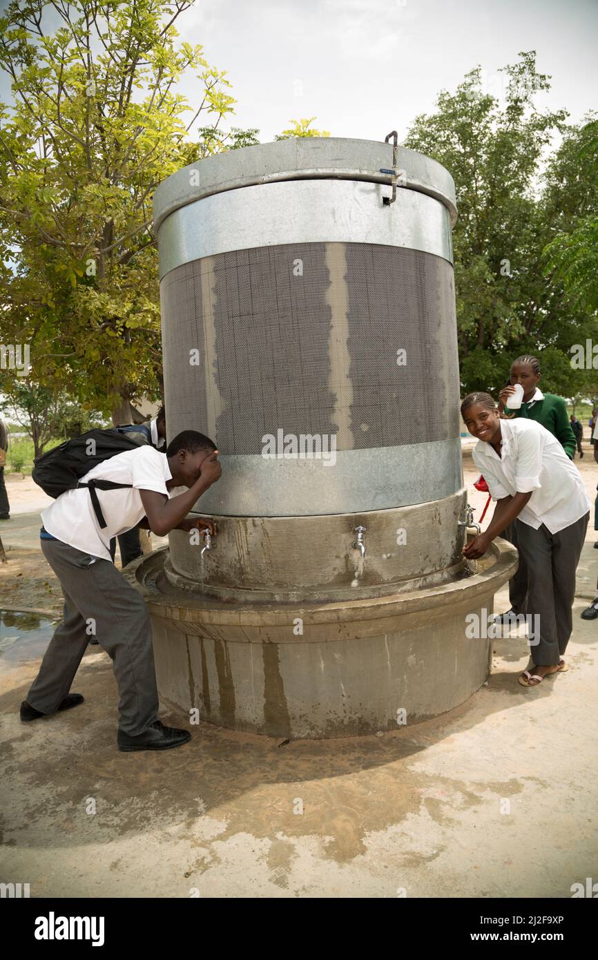 School students access clean drinking and washing water from a fountain in their school courtyard in Oshana Region, Namibia, Africa. Stock Photo