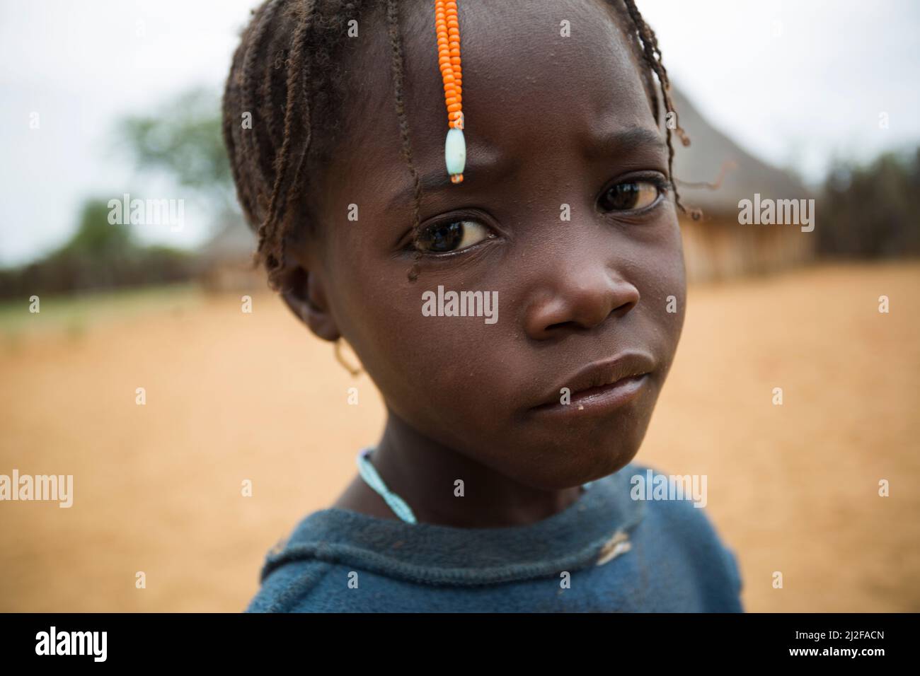 Girl with traditional hair braids and a sad expression in Omusati Region, Namibia, southwest Africa. Stock Photo