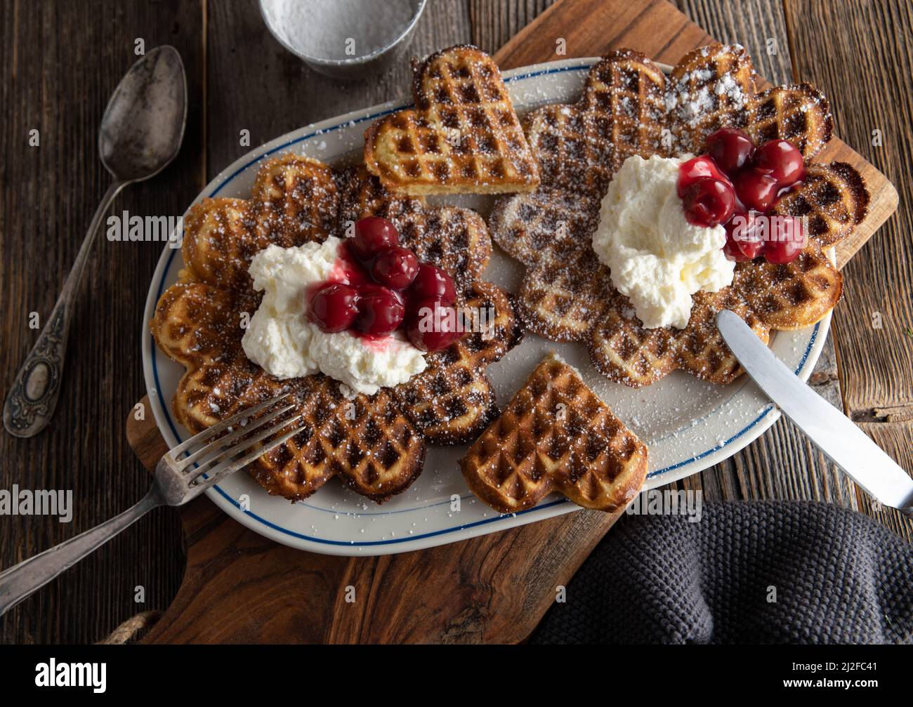 Traditional german waffles with sour cherries and whipped cream. Served