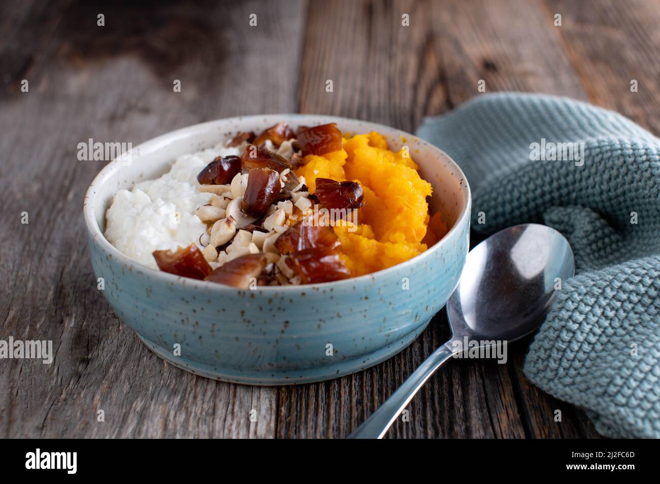 Grain free breakfast bowl for fitness and sport nutrition with high protein cottage cheese, pureed pumpkin, dates and nuts. Stock Photo