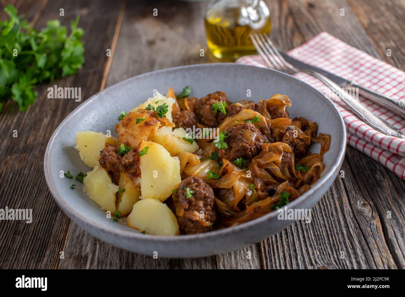 Meatball dish with fried cabbage, brown sauce and potatoes Stock Photo