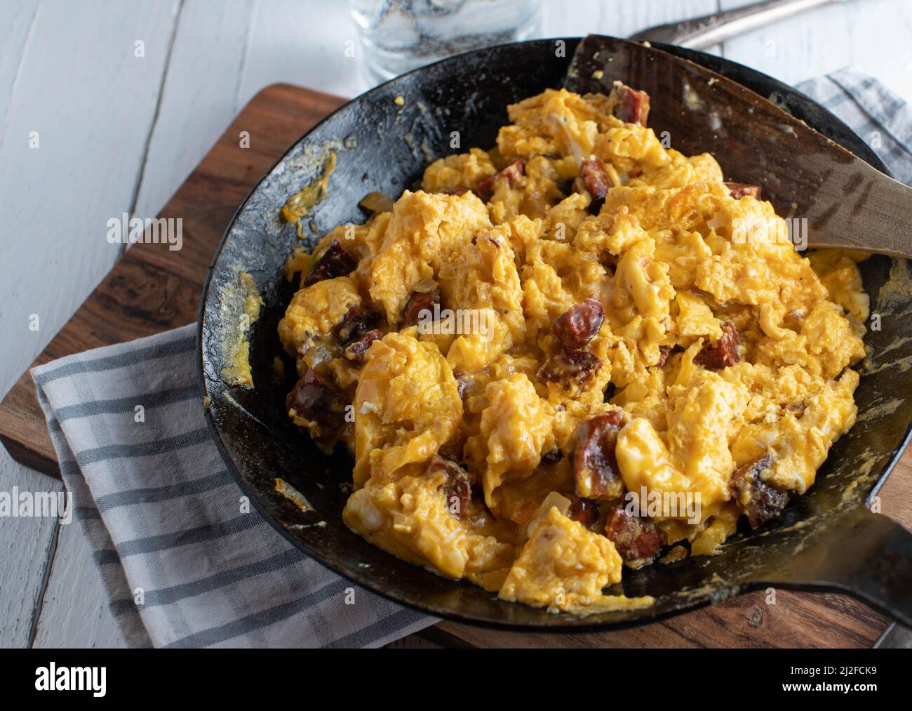 Scrambled eggs with chorizo in cast iron pan Stock Photo