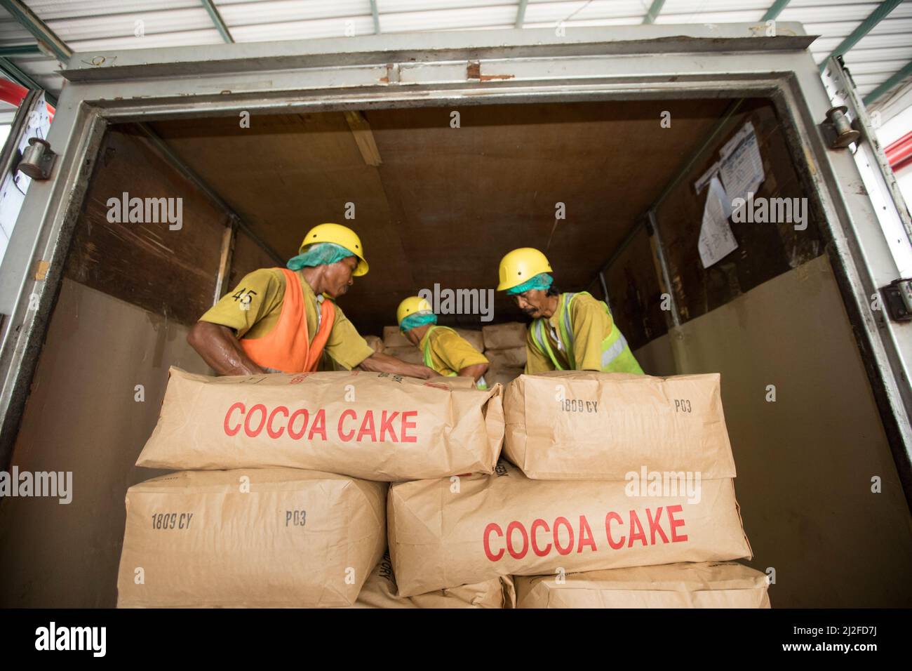 Workers unloading cocoa cake Mars Chocolate Indonesia warehouse in West Sulawesi, Indonesia