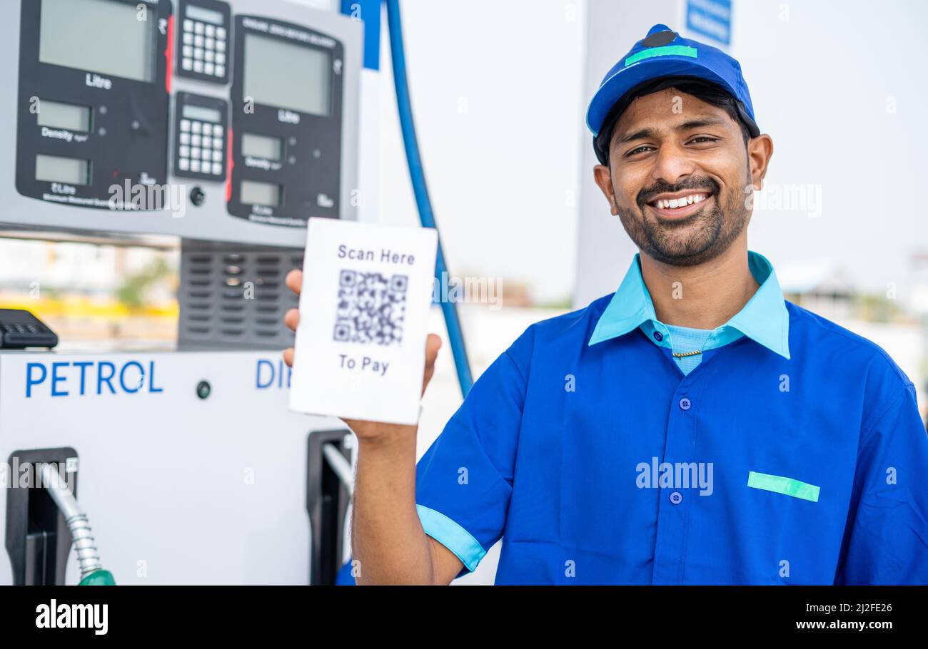 rack focus shot of petrol pump worker showing scan here to pay qr code for payment by looking at camera - concept of online or contact less payment at Stock Photo