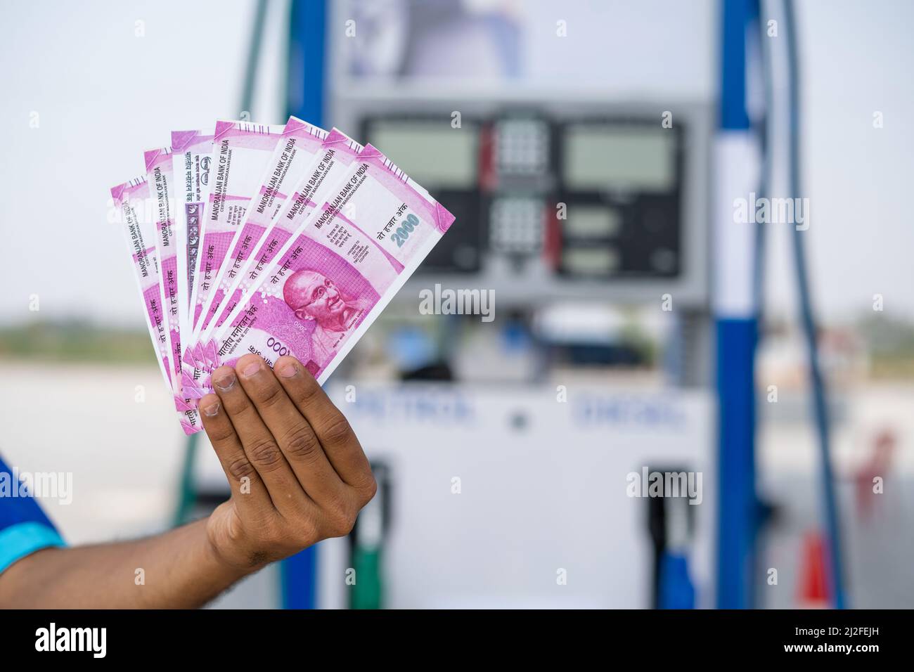 Close up shot of, fuel station worker hands counting money at petrol pump - concept of business bonus, profit and salary Stock Photo