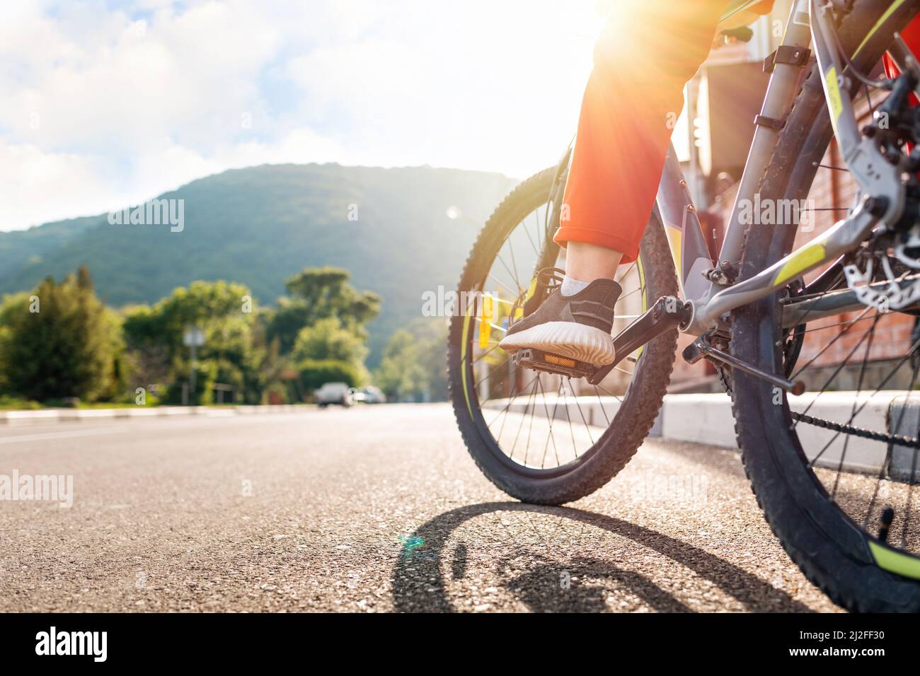 Cycling. A woman in red sportswear is sitting on a Bicycle with her