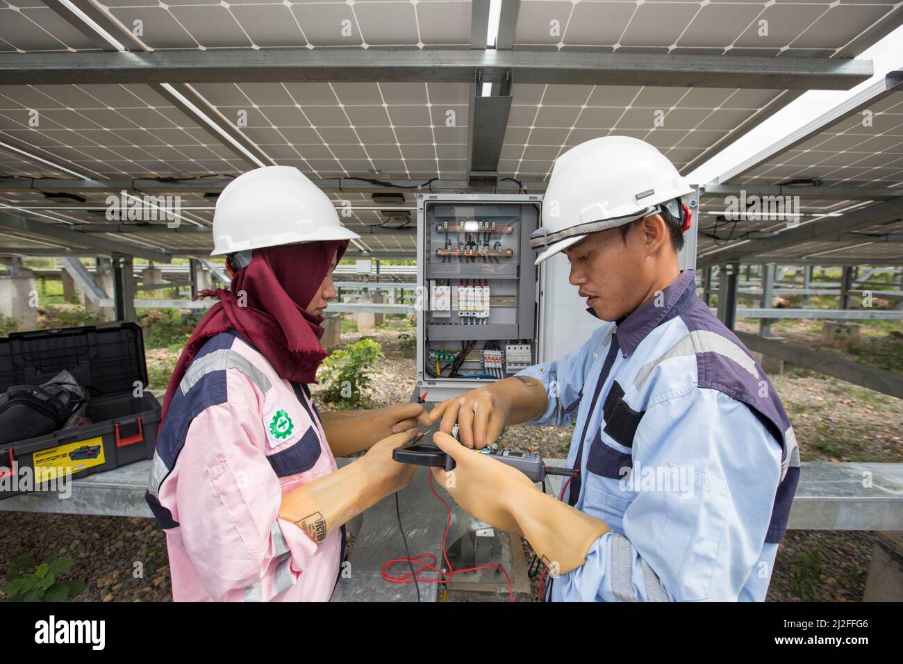 Junior electrical technicians, Aldi (25, r) and Verawati (25, l) inspect and maintain solar panels on Karampuang Island, Indonesia, which were install Stock Photo