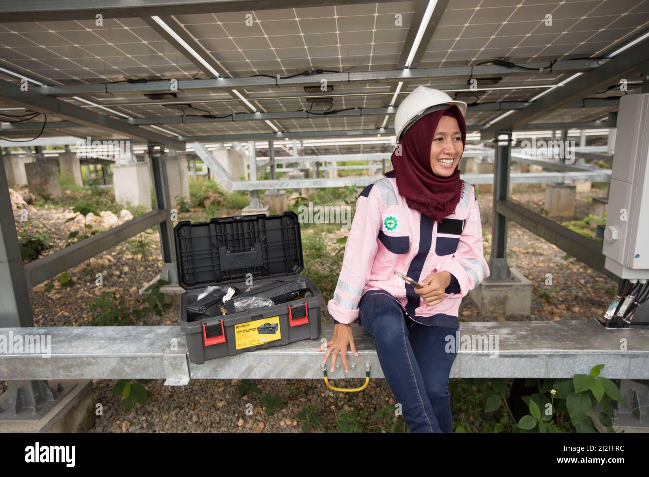 Junior electrical technician, Verawati (23), inspects and maintains solar panels on Karampuang Island, Indonesia, which were installed as part of the Stock Photo
