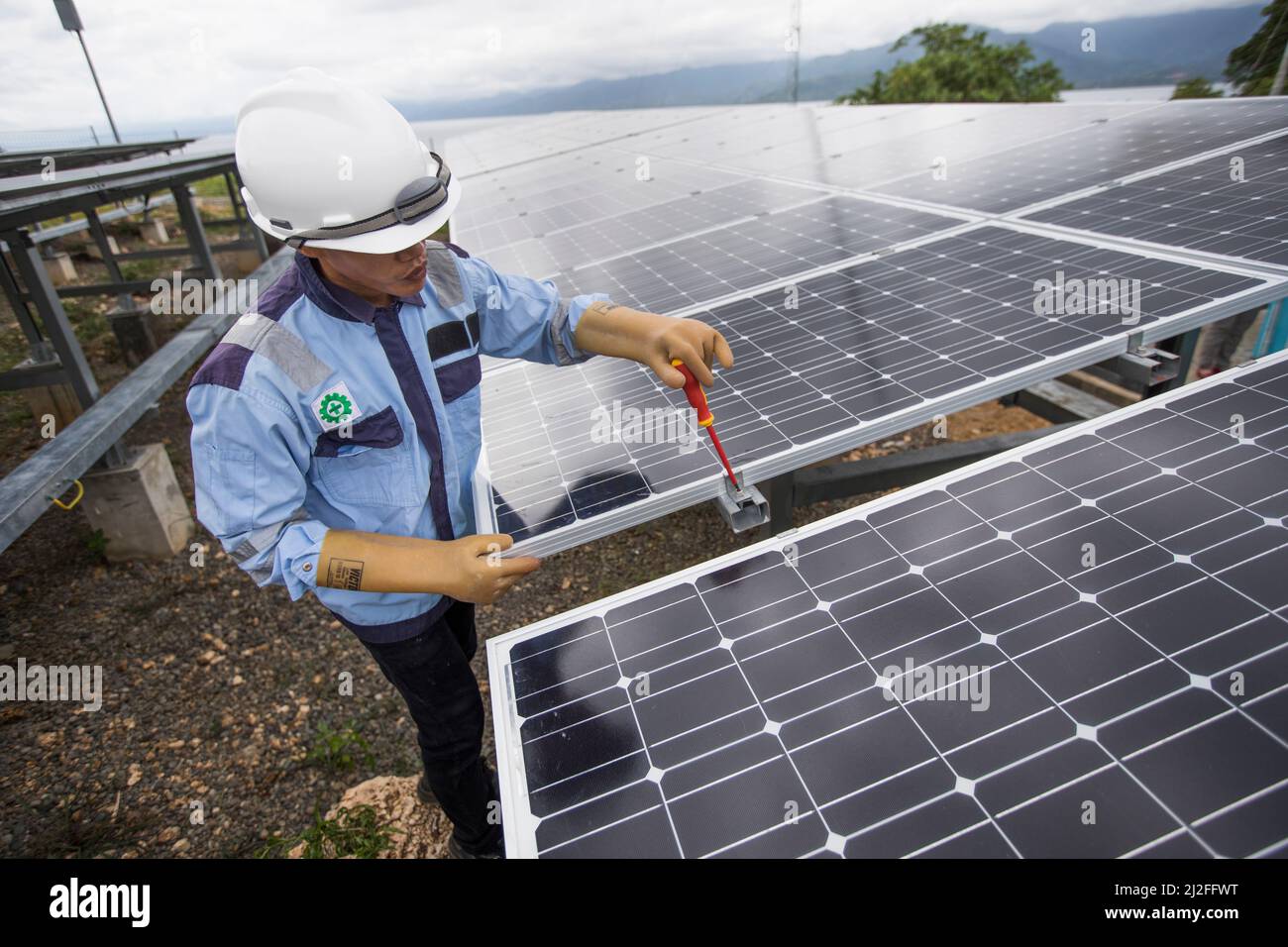 Junior electrical technician, Aldi (25), inspects and maintains solar panels on Karampuang Island, Indonesia, which were installed as part of the Gree Stock Photo