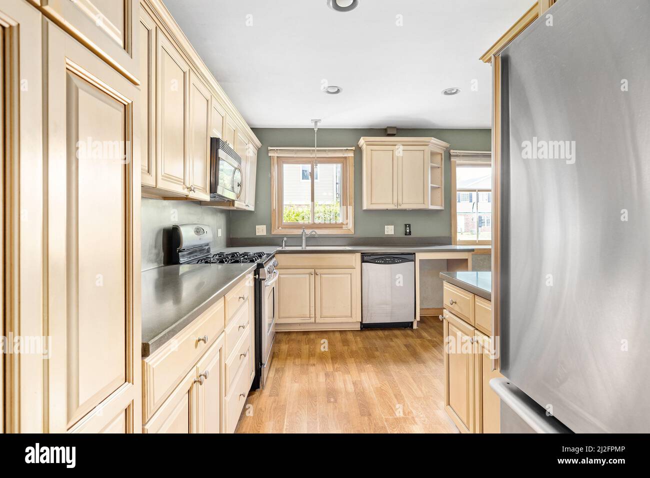An apartment kitchen with light wood stainless steel