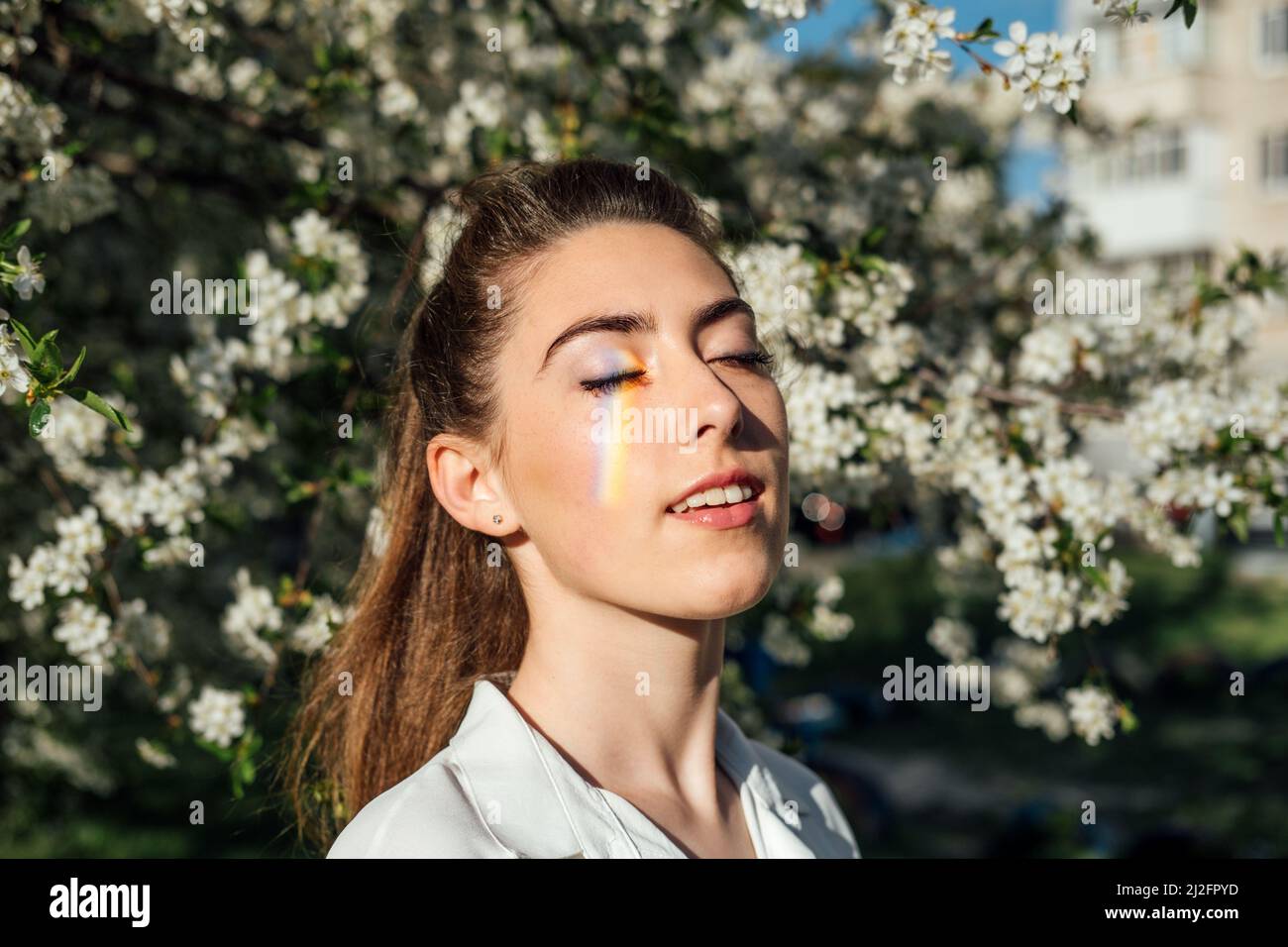 Outdoor portrait of happy ukrainian woman in cherry blossom garden ...