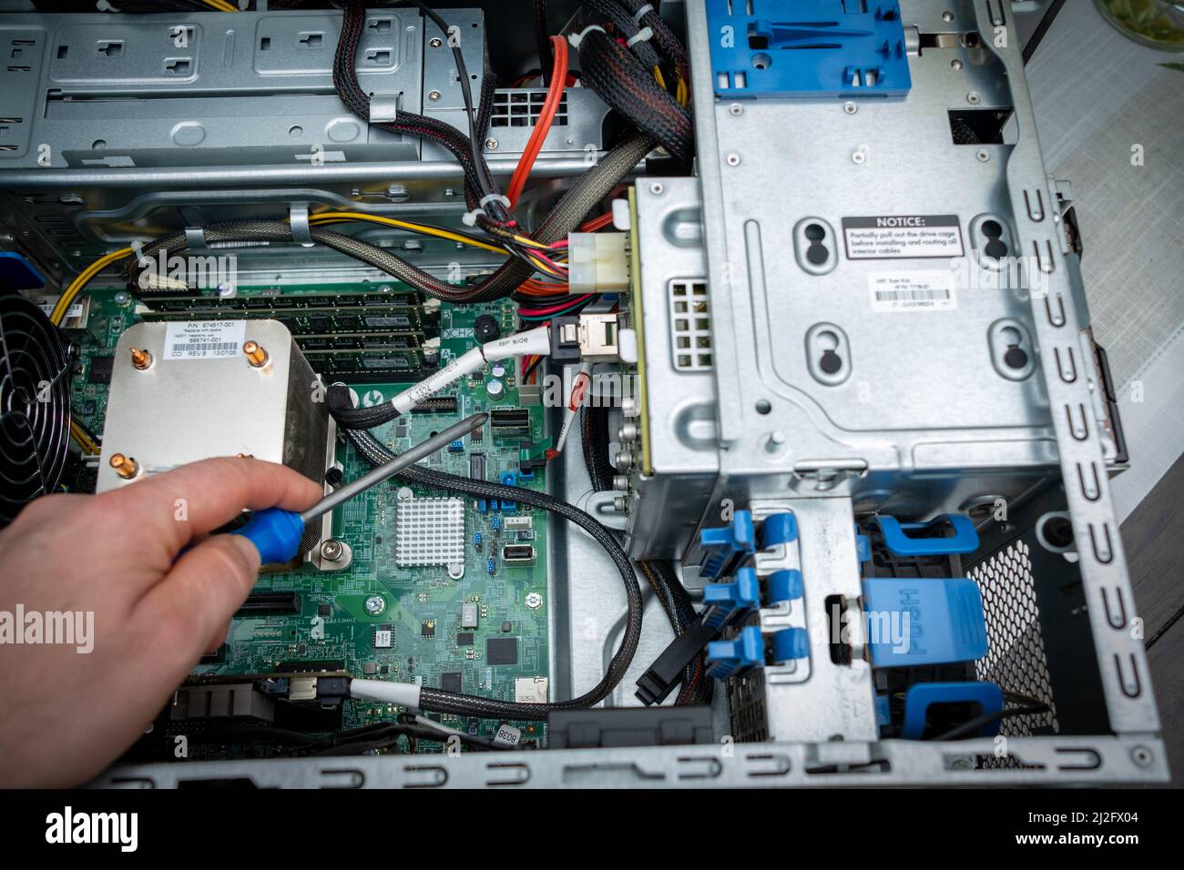 a screwdriver is held in an unscrewed PC Stock Photo