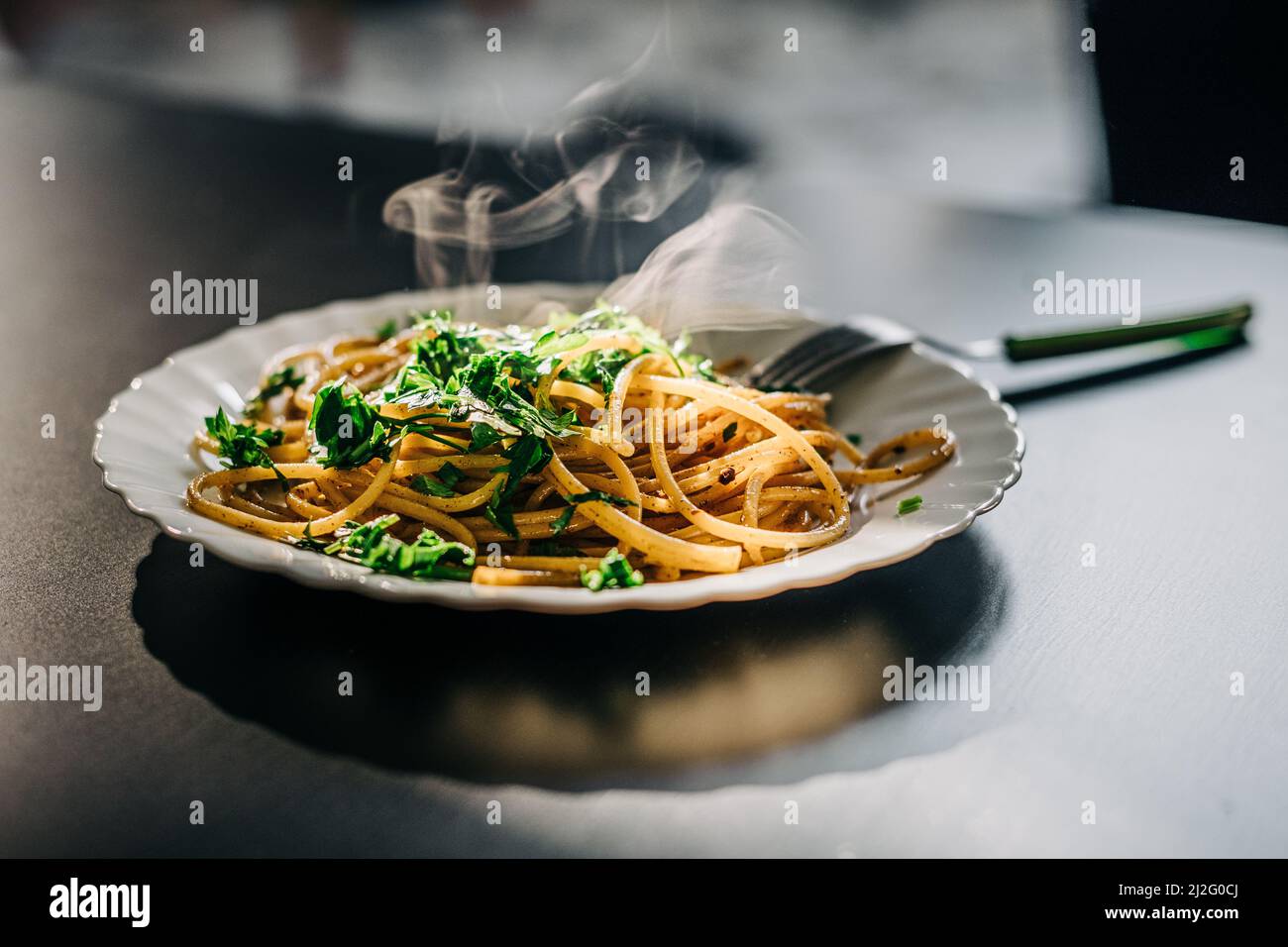 Traditional italian pasta with oil and garlic on the blasck table. Italian spaghetti Aglio Olio.  Stock Photo