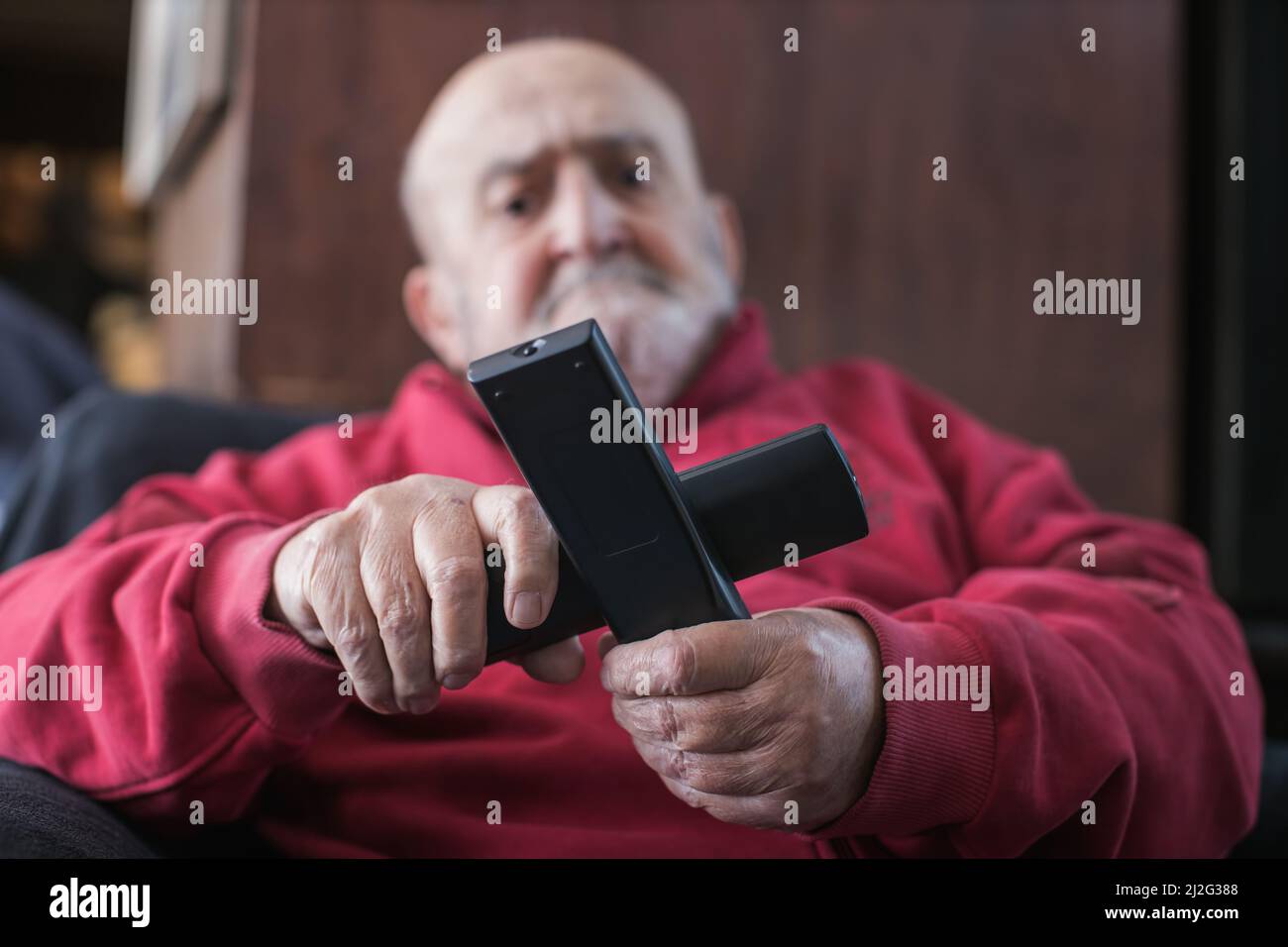 old man confused with tv remote controls Stock Photo