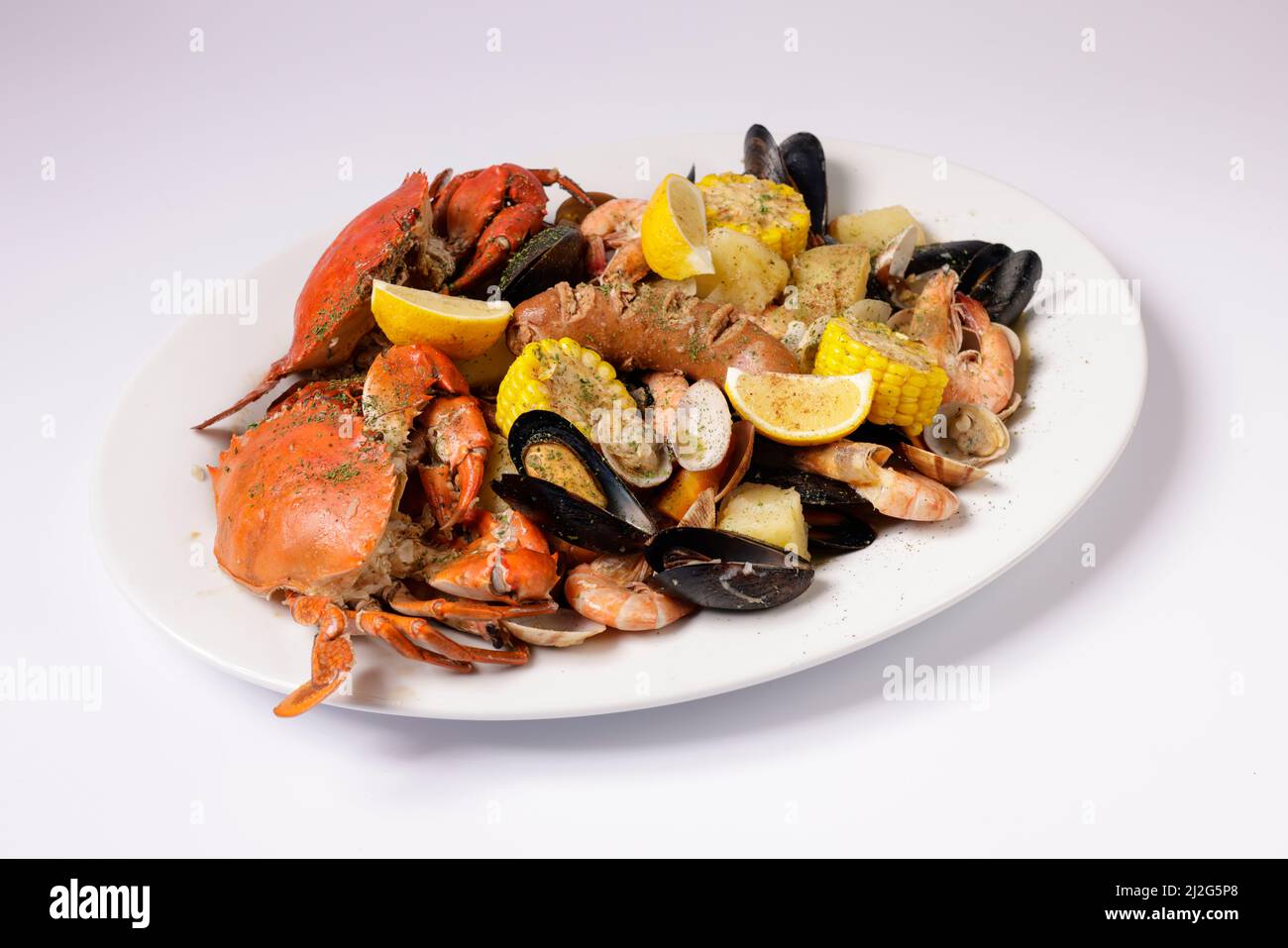 CRAB AND SEAFOOD CLAWDADDY BOIL in a dish top view on grey background