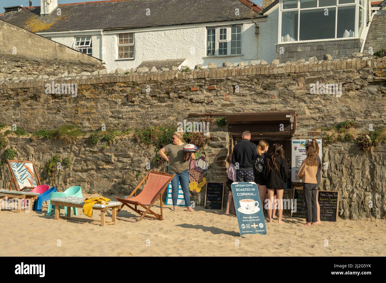 UK holidays. A group of people queue at a café on the sands at Porth Beach, Cornwall, UK. Credit: Hazel Plater/Alamy Stock Photo