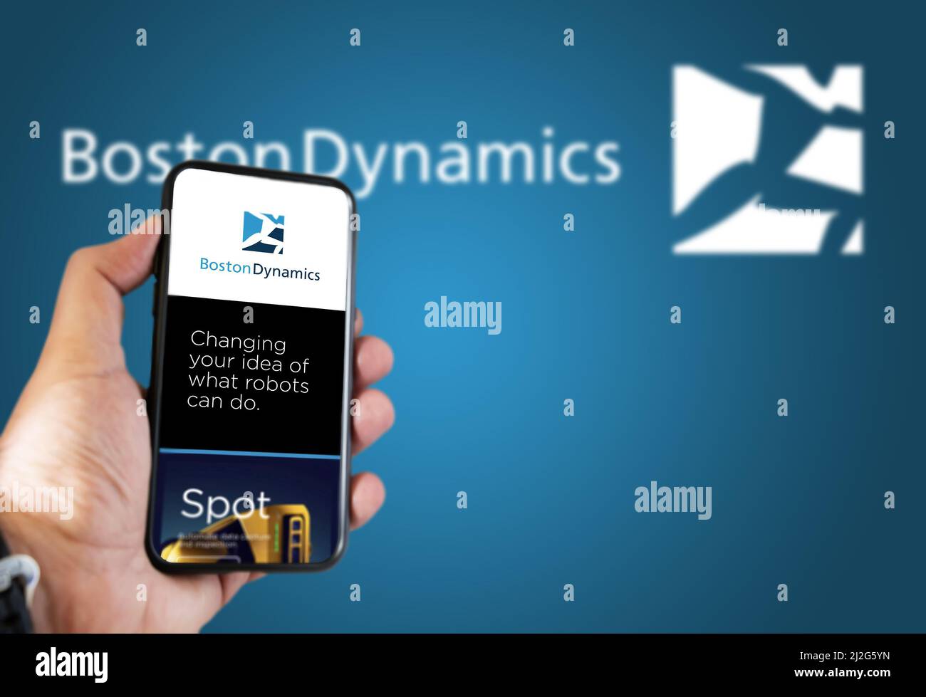 Waltham, MA, USA March 2022: Boston Dynamics company’s website on a phone screen. Blue background with Boston Dynamics logo blurred in the background. Stock Photo