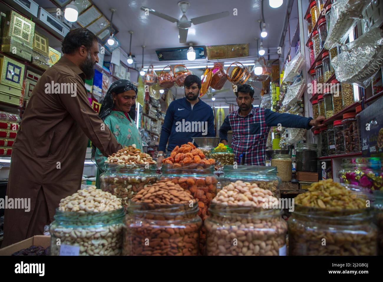 Kashmiri woman buying dry fruits at a shop in a local market in