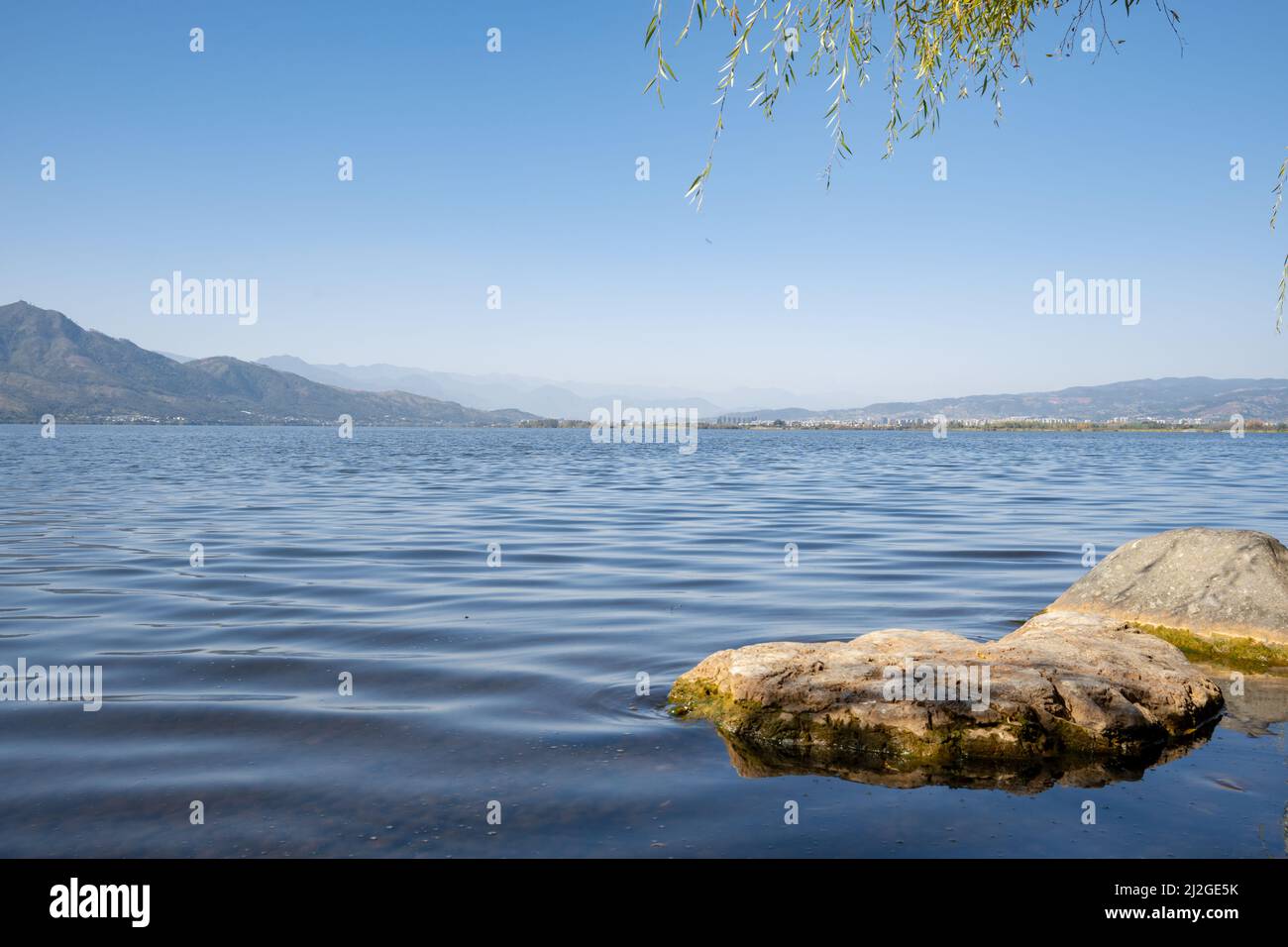 A scenic lake under a hazy blue sky Stock Photo - Alamy