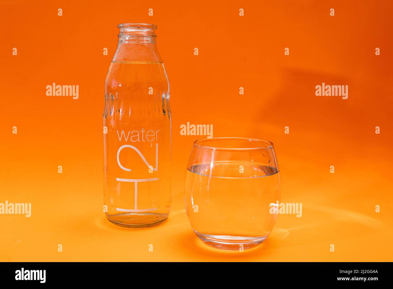 https://c8.alamy.com/comp/2J2GG4A/bottle-and-glass-tumbler-with-purified-water-in-orange-and-light-orange-gradient-background-ecology-concept-environment-care-water-care-2J2GG4A.jpg