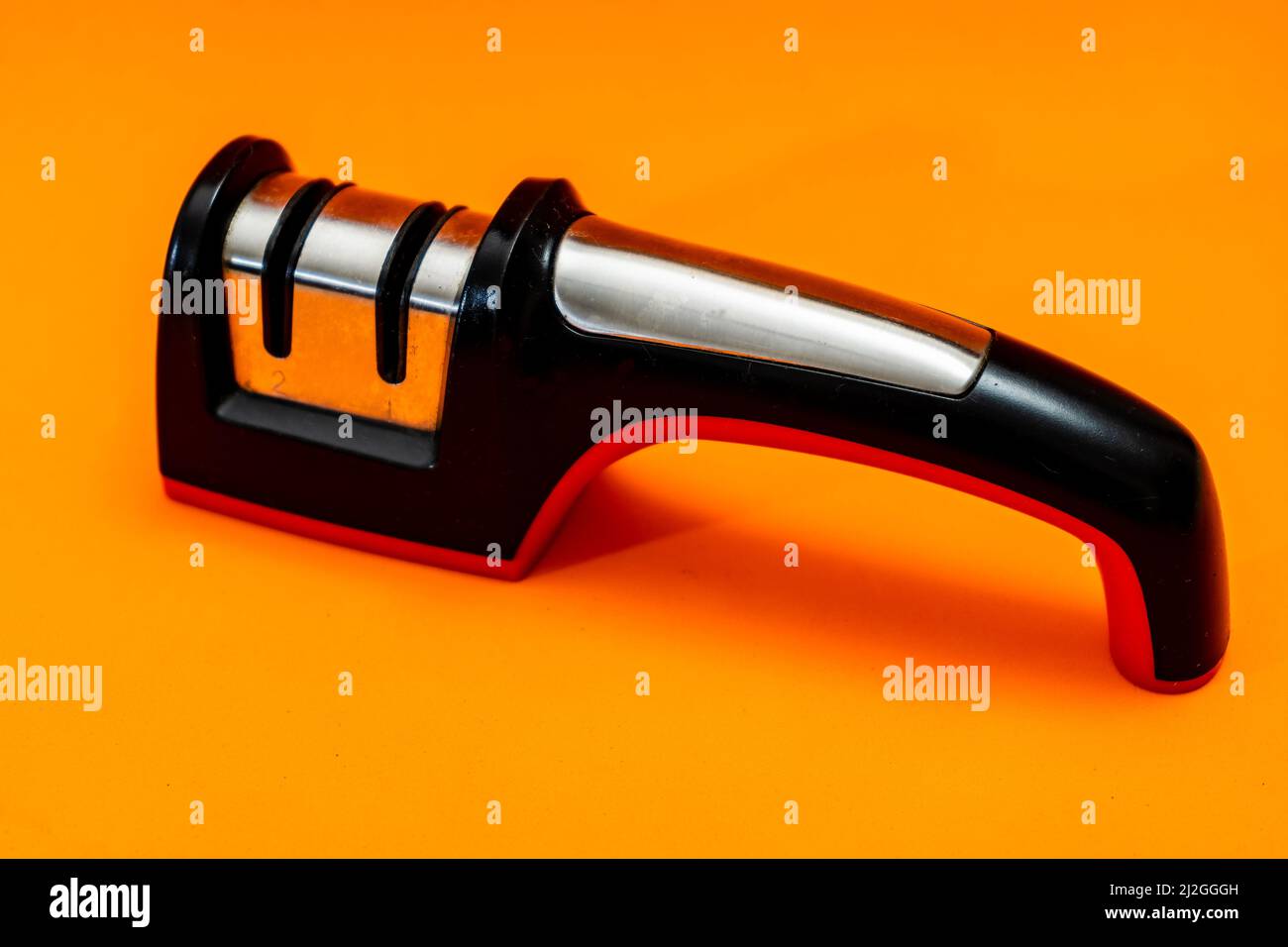 Knife sharpener isolated on an orange background. Stock Photo