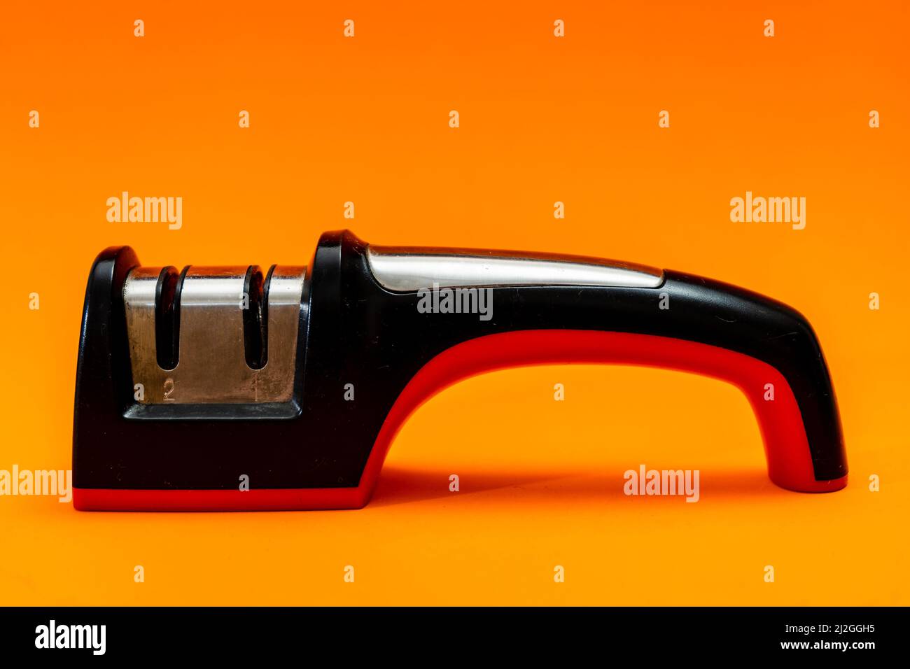 Knife sharpener isolated on an orange background. Stock Photo
