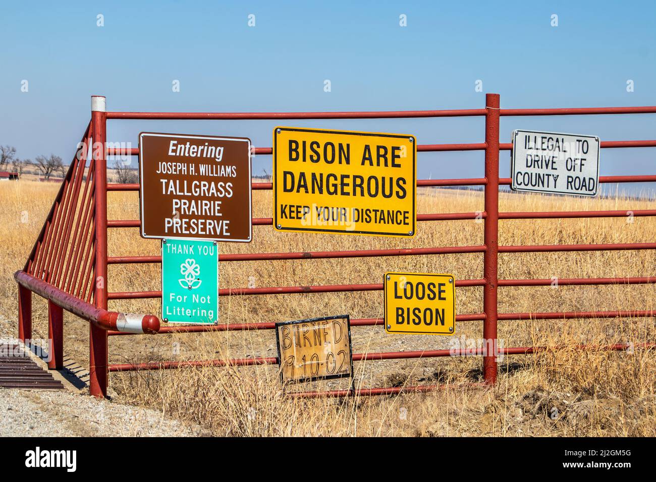 3 16 2022 Tall Grass Prairie Oklahoma USA - Signs on metal fence at edge of buffalo reserve in NE Oklahoma - Bison are Dangerous Stock Photo