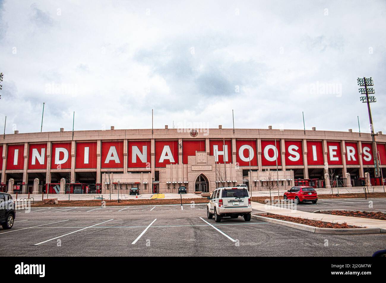 2021-03-26-Bloomington Indiana USA - Side view of Hoosier Indiana Football stadium and ticket offices with parking lot in foreground and a few parked Stock Photo