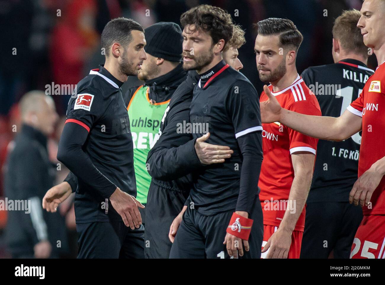 01 April 2022, Berlin: Soccer: Bundesliga, 1. FC Union Berlin - 1. FC Köln, Matchday 28, An der Alten Försterei. Florian Kainz (2nd from left) of Cologne and teammates stand disappointed on the pitch. Berlin's Niko Gießelmann and Timo Baumgartl (r) offer consolation. Photo: Andreas Gora/dpa - IMPORTANT NOTE: In accordance with the requirements of the DFL Deutsche Fußball Liga and the DFB Deutscher Fußball-Bund, it is prohibited to use or have used photographs taken in the stadium and/or of the match in the form of sequence pictures and/or video-like photo series. Stock Photo