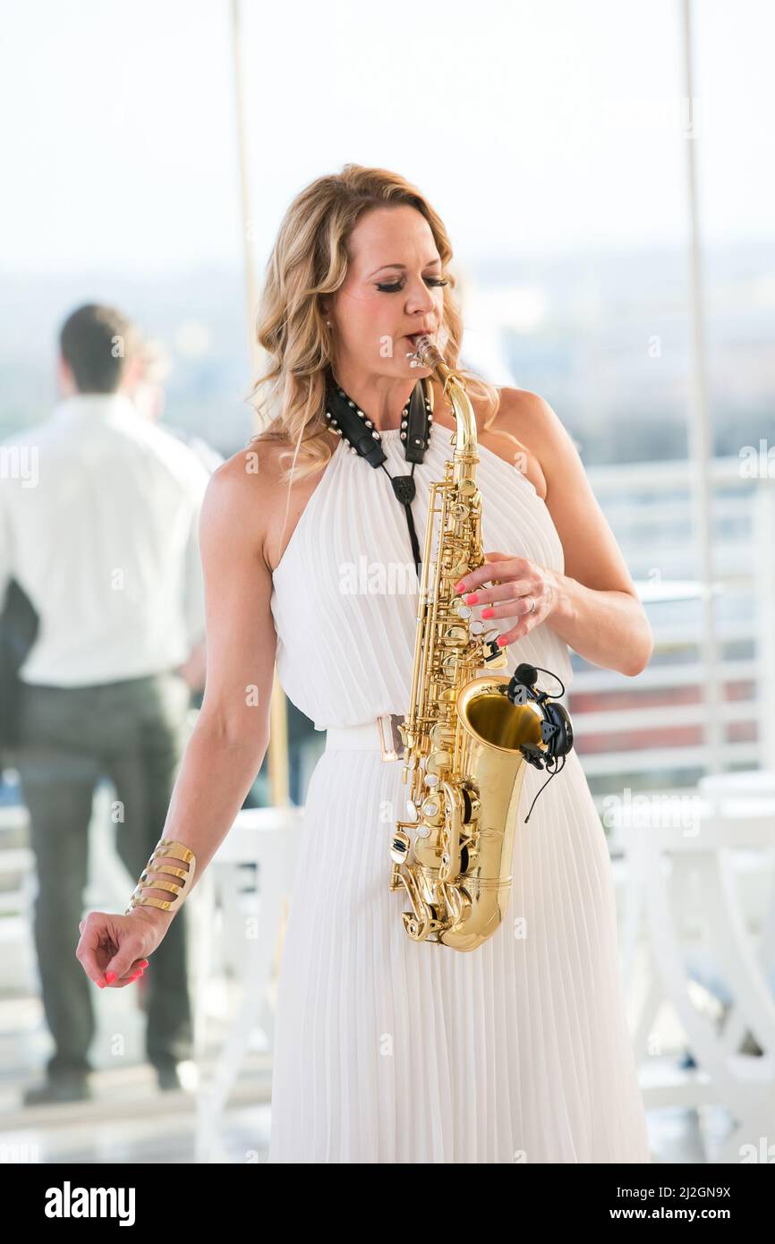 A female saxophonist playing saxophone at corporate event in