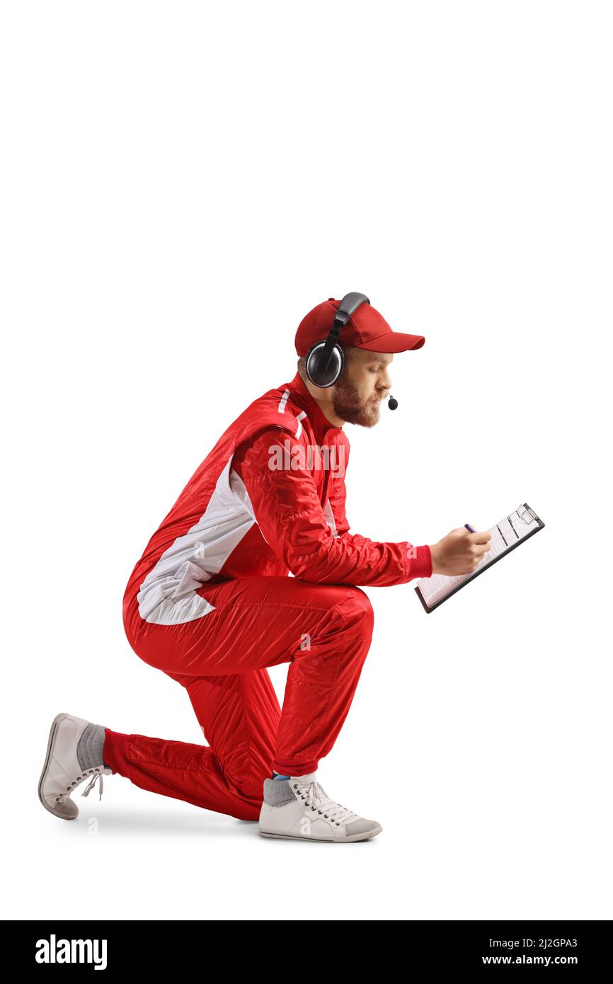 Member of a racing team kneeling and writing on a clipboard isolated on white background Stock Photo