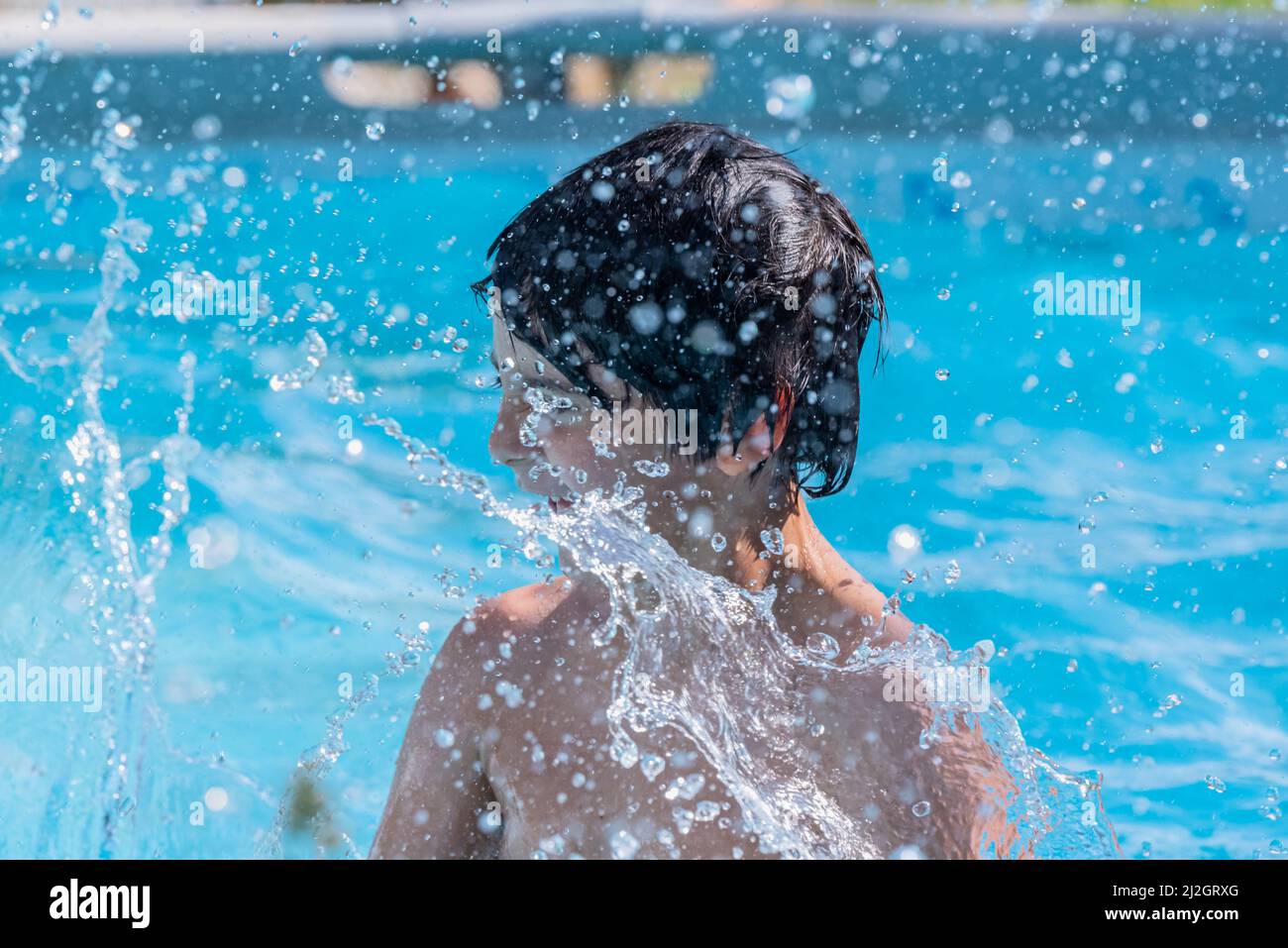 one caucasian child play to splash water out of swiming pool Stock