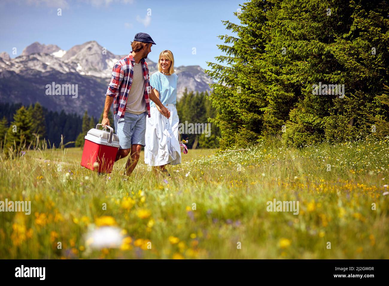 Young cheerful smiling man and woman in love holding hands and walking in nature on a beautiful  day. Stock Photo