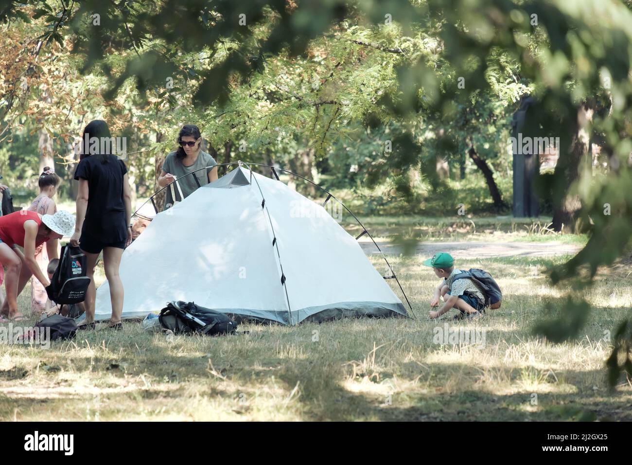 SOFIA, BULGARIA - AUGUST 04, 2017: women teaching to children how to pitch a tent in a Sofia Park Stock Photo