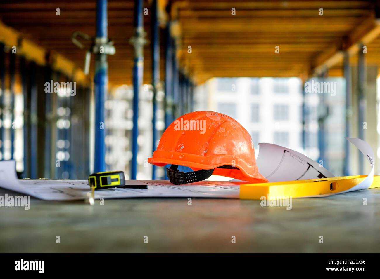 Blueprints project building, construction level and helmet, close up ...