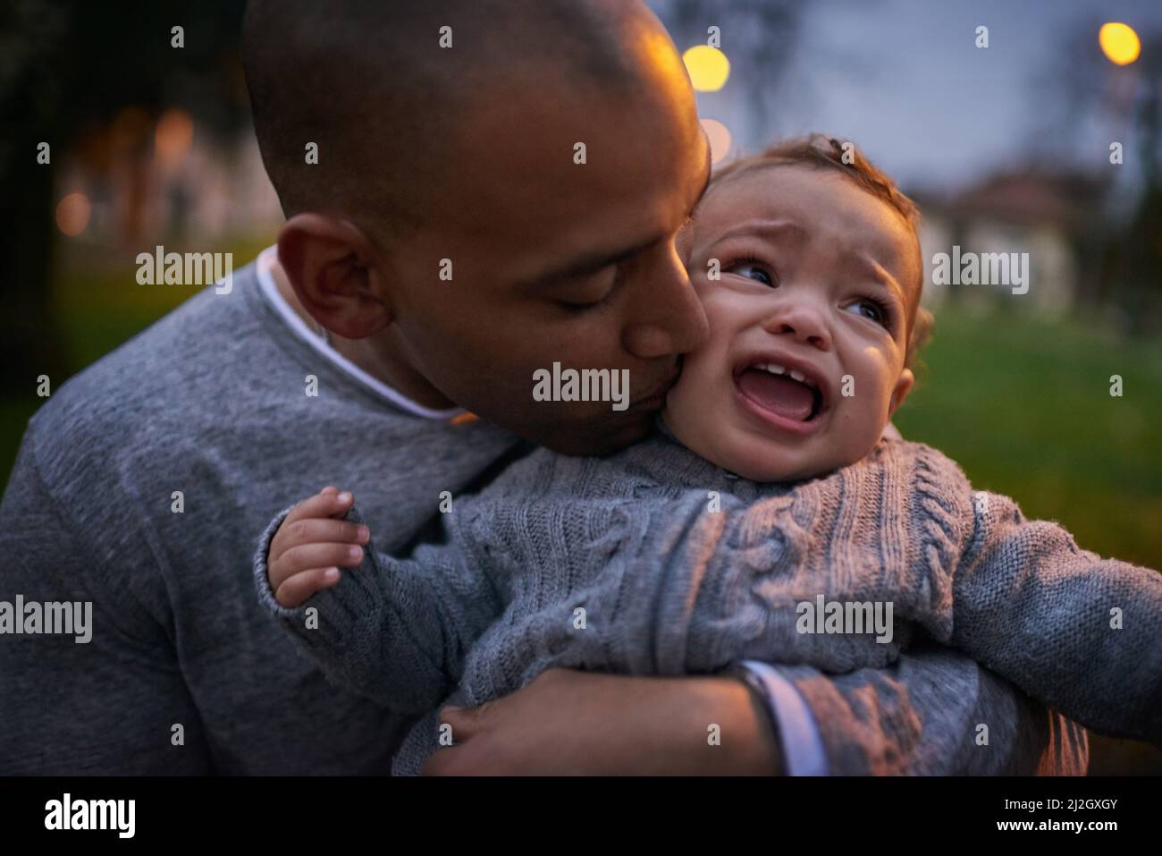 Dont cry buddy, Im right here. Shot of a father comforting his crying son outdoors. Stock Photo