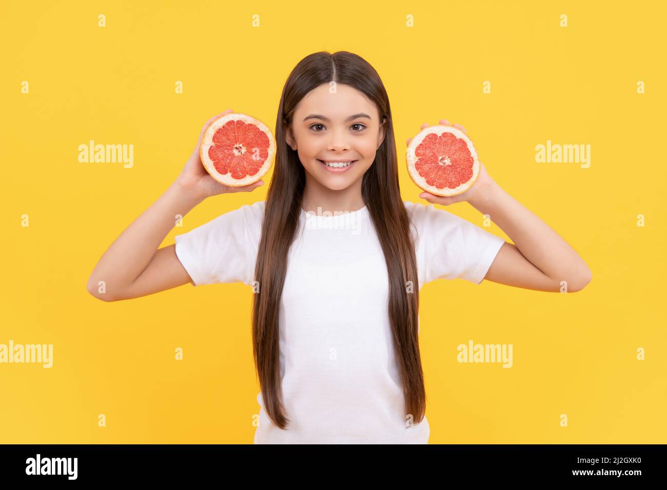 glad teen girl with grapefruit. vitamin and dieting. child eating healthy food. Stock Photo