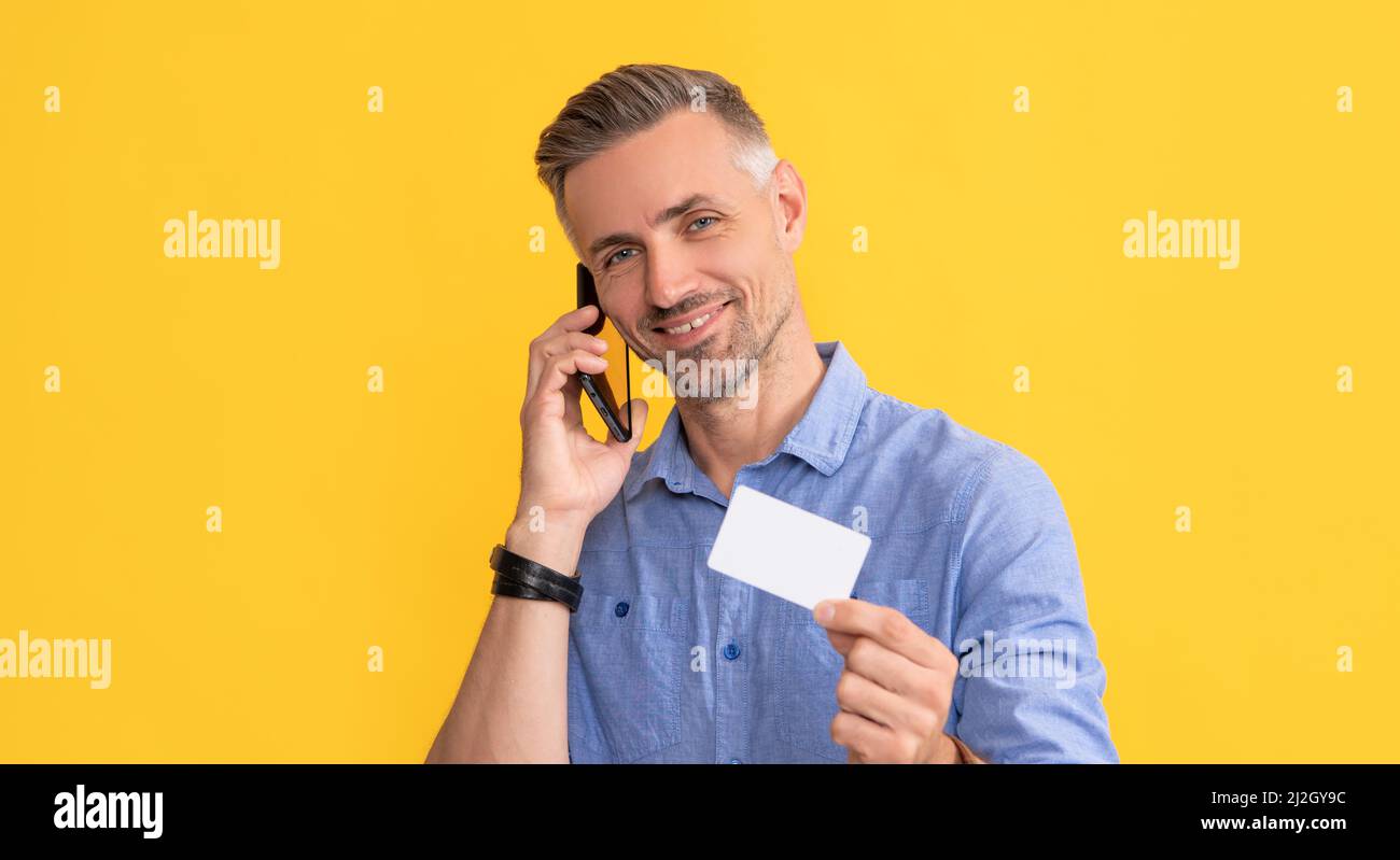 happy man speak on mobile phone showing debit card with copy space, identification Stock Photo