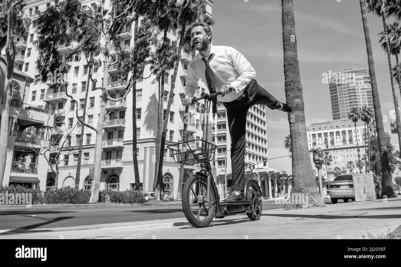 Street recreation. Happy employer ride escooter on sidewalk. E-scooting for recreation and fun Stock Photo